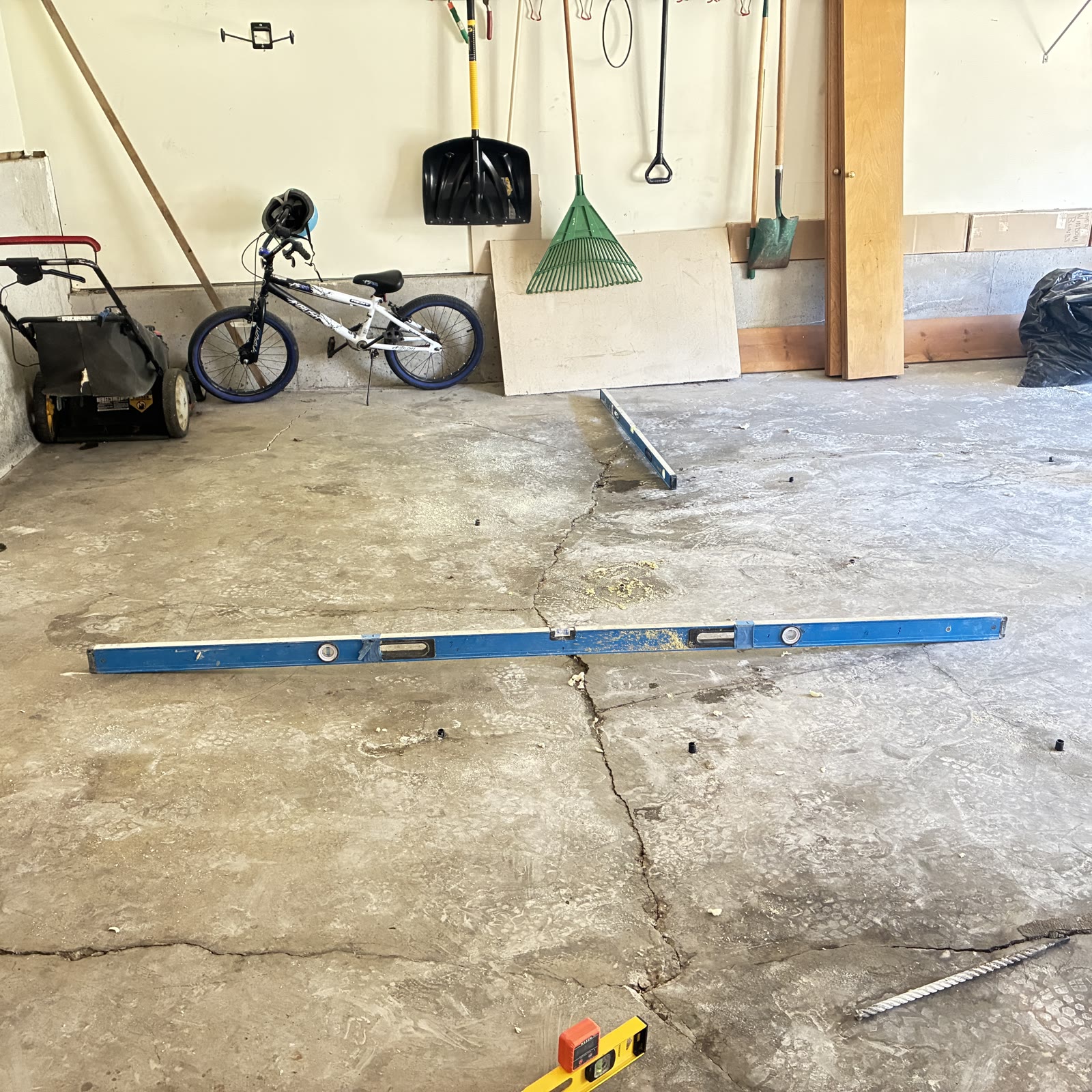 KC MudJack technician inspecting and stabilizing a garage floor